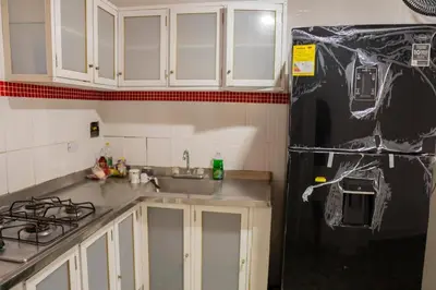 a kitchen with white cabinets and a black refrigerator at Cabaña Playa Azul in Coveñas