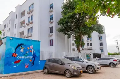two cars parked in a parking lot in front of a building at Acogedor apto en Coveñas 401 in Coveñas