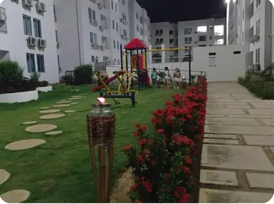 a park with a playground with red flowers and buildings at Acogedor apto en Coveñas 401 in Coveñas