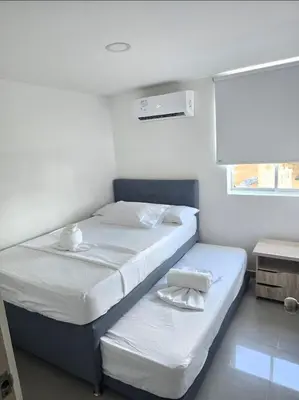 a small bedroom with two beds and a window at Acogedor apto en Coveñas 204 in Coveñas