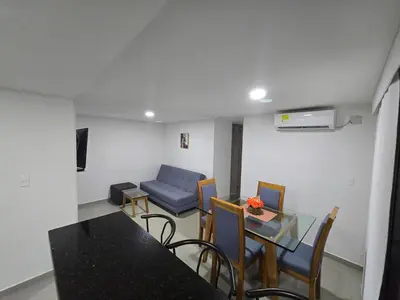 a living room with a table and a blue couch at Acogedor apto en Coveñas 204 in Coveñas