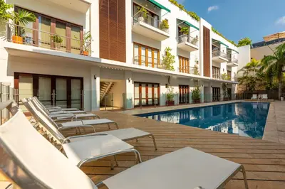 a hotel with a swimming pool and lounge chairs at Apartamento Virrey in Cartagena de Indias