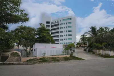 a large white building with a fence in front of it at Hermoso Apartamento Frente al Mar 3 Habitaciones MSC34 in Estación El Salto