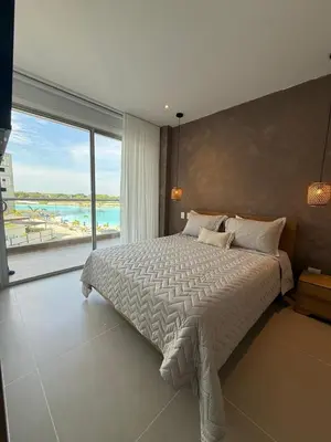a bedroom with a large bed and a large window at Vista a la laguna - Baia Kristal in Los Arrayanes