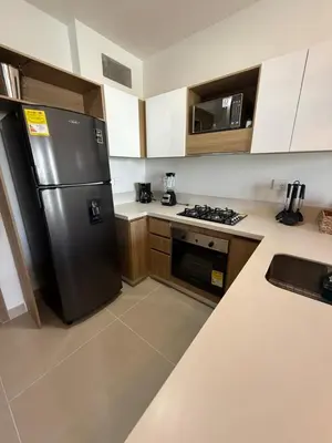 a kitchen with a stainless steel refrigerator and wooden cabinets at Vista a la laguna - Baia Kristal in Los Arrayanes