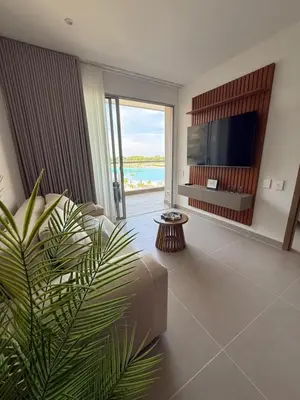 a living room with a tv and a couch and a plant at Vista a la laguna - Baia Kristal in Los Arrayanes