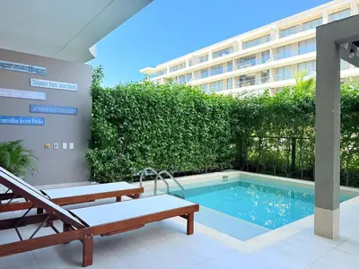 a swimming pool with two benches and a building at Shoreline Escape - Private Pool - Beach in Cartagena de Indias