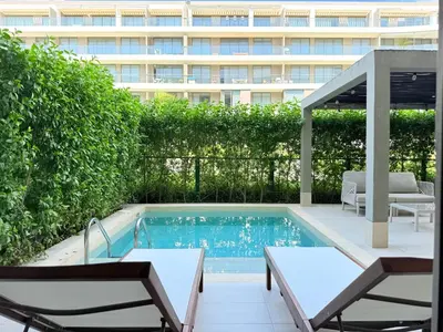 a swimming pool with two chairs and a building at Shoreline Escape - Private Pool - Beach in Cartagena de Indias
