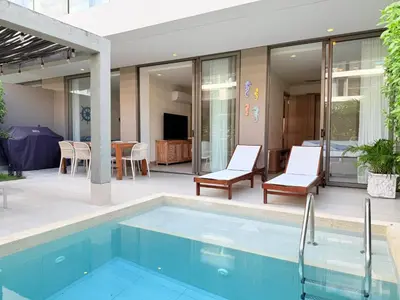 a swimming pool with two chairs and a table at Shoreline Escape - Private Pool - Beach in Cartagena de Indias