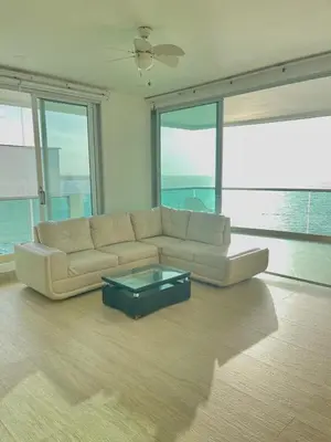 a living room with a white couch and a glass table at Apartamento frente al mar in Coveñitas