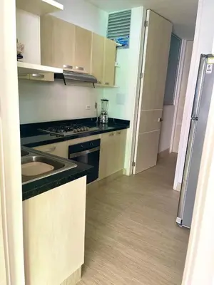 a small kitchen with a stove and a refrigerator at Apartamento frente al mar in Coveñitas