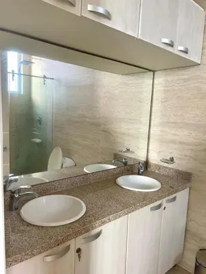 a bathroom with two sinks and a large mirror at Apartamento frente al mar in Coveñitas