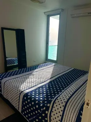 a bedroom with a blue and white bed with a window at Apartamento frente al mar in Coveñitas
