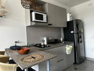 a kitchen with a counter with a microwave and a refrigerator at New luxury studio apartment with ocean view, Santa Marta in Simón Bolivar