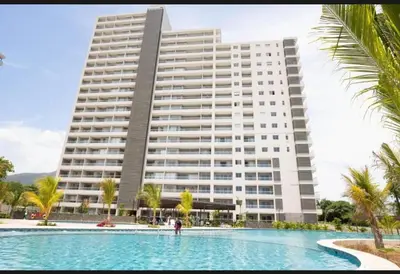 a large building with a swimming pool in front of a building at New luxury studio apartment with ocean view, Santa Marta in Simón Bolivar