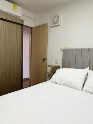 a bedroom with a white bed and a wooden door at Moderno Rincón Urbano in Cartagena de Indias
