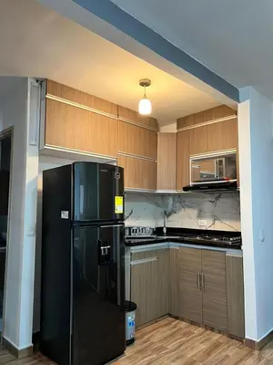 a kitchen with a black refrigerator and wooden cabinets at Moderno Rincón Urbano in Cartagena de Indias