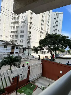 a person with an umbrella standing on a street with tall buildings at Moderno Rincón Urbano in Cartagena de Indias