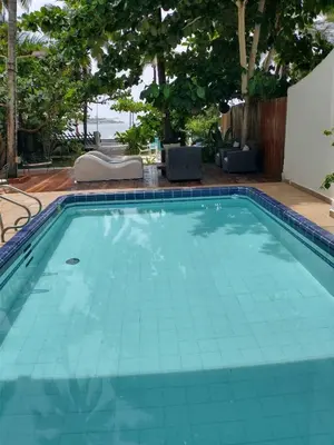 a swimming pool with a blue tile floor and trees at Casa - EL LAGUITO in Cartagena de Indias