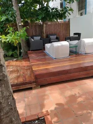 a wooden deck with two white chairs and a table at Casa - EL LAGUITO in Cartagena de Indias