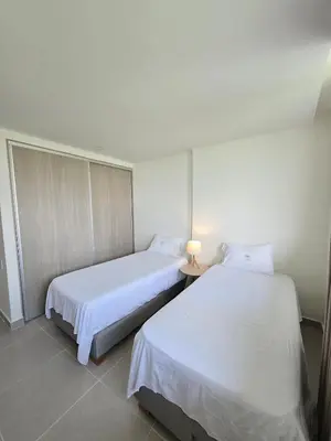 two beds in a room with white sheets at Estilo y confort en cartagena, a pasos del mar in Cartagena de Indias
