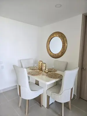 a dining room table with white chairs and a mirror at Estilo y confort en cartagena, a pasos del mar in Cartagena de Indias