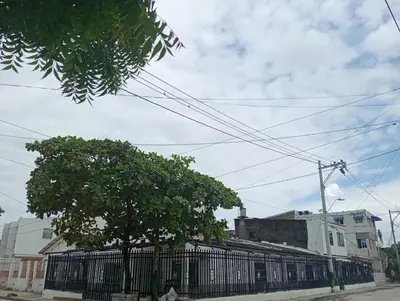 a building with a fence and a tree on a street at Cartagena brisa y caracol in Cartagena de Indias