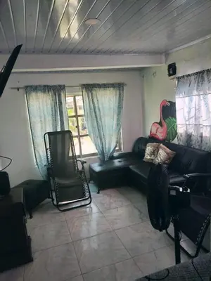 a living room with a black leather couch and windows at Cartagena brisa y caracol in Cartagena de Indias