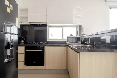 a kitchen with white cabinets and a black appliance at Ocean view apartment in Cartagena de Indias