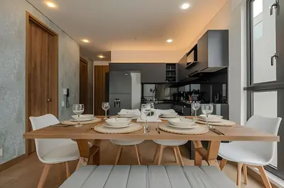 a dining room with a wooden table and white chairs at New Murano Centro/Near Walled City/Panoramic Pool in Cartagena de Indias