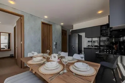 a kitchen with a wooden table with plates and wine glasses at New Murano Centro/Near Walled City/Panoramic Pool in Cartagena de Indias