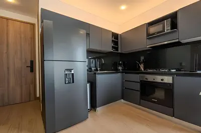 a kitchen with stainless steel appliances and black cabinets at New Murano Centro/Near Walled City/Panoramic Pool in Cartagena de Indias