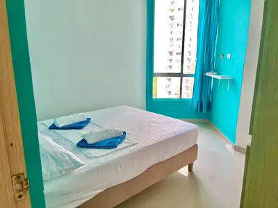 a bedroom with a bed with blue walls and a window at Apartamento en Cartagena cerca al mar in Cartagena de Indias
