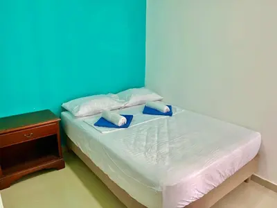 a bed with two pillows and a blue wall at Apartamento en Cartagena cerca al mar in Cartagena de Indias