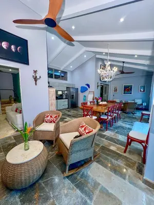 a living room with a ceiling fan and a dining room at Cabaña privada con piscina y jacuzzi junto al mar in Santa Veronica