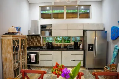 a kitchen with a stainless steel refrigerator and a window at Cabaña privada con piscina y jacuzzi junto al mar in Santa Veronica