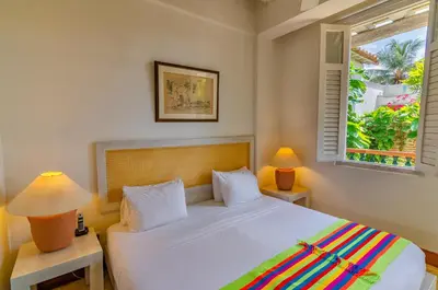 a bedroom with a white bed with two lamps and a window at Casa Pizarro Hotel Boutique in Cartagena de Indias