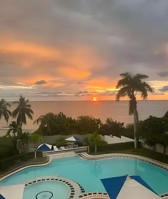 a view of the pool at the resort at sunset at Apartamento de playa privada in Santa Marta
