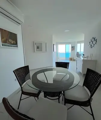 a dining room with a glass table and chairs at Apartamento de playa privada in Santa Marta