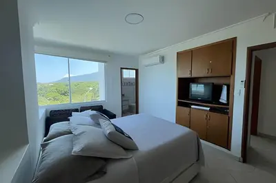a bedroom with a bed with pillows and a television at Apartamento de playa privada in Santa Marta
