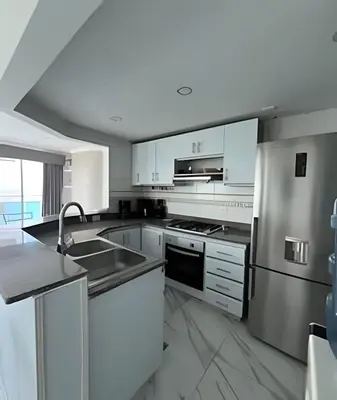 a kitchen with white cabinets and stainless steel appliances at Alojamiento exclusivo frente al mar in Santa Marta