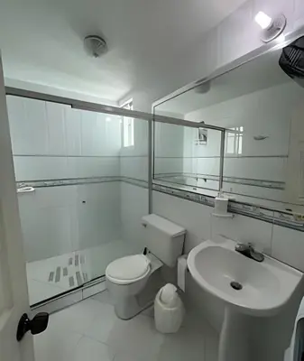 a white bathroom with a toilet and a sink at Alojamiento exclusivo frente al mar in Santa Marta