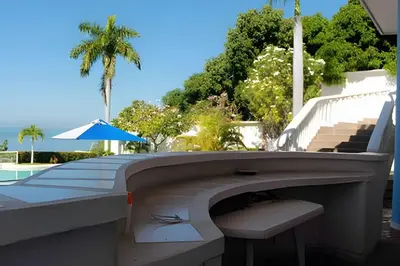 a bench next to a pool with a chair and an umbrella at Alojamiento exclusivo frente al mar in Santa Marta