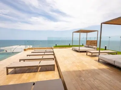 a row of beds on a deck with the ocean at Loft cercano al Centro Histórico-Cartagena in Cartagena de Indias