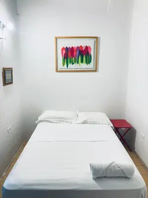 a bed in a room with a painting on the wall at Auténtico apartamento en centro histórico con arte in Cartagena de Indias