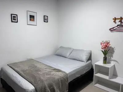 a white bedroom with a bed and a vase of flowers at CasaMartina in Cartagena de Indias