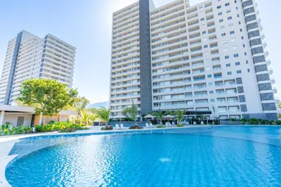 a large swimming pool in front of two tall buildings at Apartamentos Exclusivos Santa Marina - AR Rentals in Santa Marta