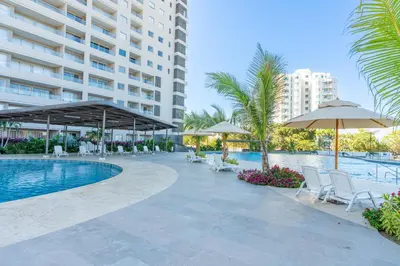 a swimming pool with umbrellas and chairs and a hotel at Apartamentos Exclusivos Santa Marina - AR Rentals in Santa Marta