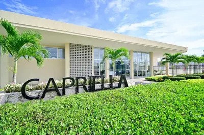 a sign in front of a building with palm trees at Apartamento en Cartagena elegante con piscina in Manzanillo del Mar