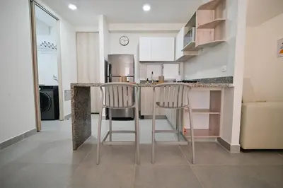 a kitchen with two bar stools at a counter at Apartamento en Cartagena elegante con piscina in Manzanillo del Mar